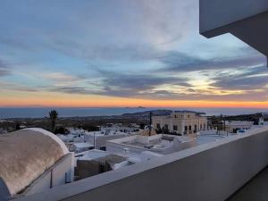 Blick auf eine Stadt vom Dach eines Gebäudes in der Unterkunft Astivi Santorini Apartments in Pirgos