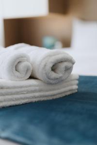 una pila di asciugamani bianchi su un letto di Faros Flat a Alexandroupoli