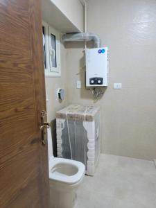 uma casa de banho com um WC e uma termosférica em Dokii no Cairo
