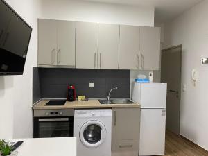 a kitchen with a washing machine and a refrigerator at Paul’s Houses in Drama +9 photos