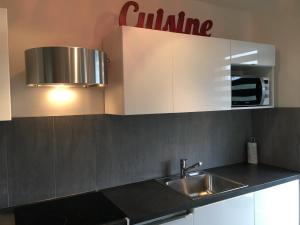 une cuisine avec un évier et un micro-ondes dans l'établissement Grand Studio design avec parking, à Neuilly-sur-Seine 1 autre photo