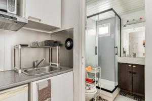 a small kitchen with a sink and a shower at Studio Pop plein Centre-Port - ménage, linge inclus in Cap d'Agde