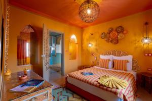 um quarto com uma cama e uma mesa num quarto em LES TANNEURS PENTHOUSE MARRAKECH em Marraquexe