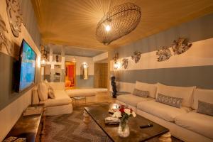 uma sala de estar com sofás brancos e uma televisão em LES TANNEURS PENTHOUSE MARRAKECH em Marraquexe