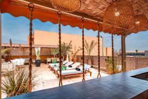 a patio with chairs and tables on a roof at LES TANNEURS PENTHOUSE MARRAKECH in Marrakesh