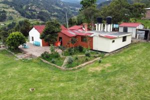 een huis op een heuvel met een tuin bij Cómoda Casa de campo con excelente ubicación in Sogamoso