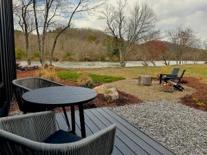 a patio with a table and chairs on a deck at Asheville River Cabins in Arden