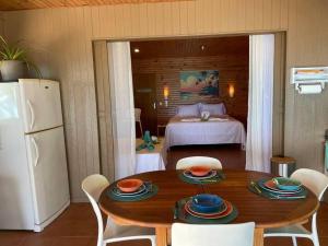 a kitchen with a table and a bedroom with a bed at Rangiroa Sunny House in Avatoru