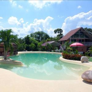 a large swimming pool in front of a building at COVEÑITAS Cabaña CARIBE, con piscina tipo playa, capacidad máxima 34 personas in Melgar