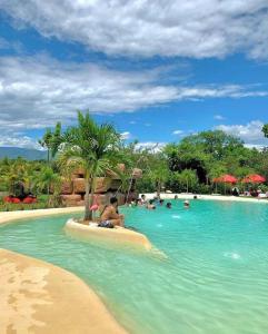 a group of people in a pool at a resort at COVEÑITAS Cabaña CARIBE, con piscina tipo playa, capacidad máxima 34 personas in Melgar