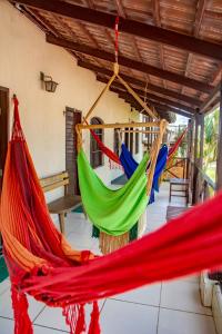 a group of hammocks hanging from a porch at Pousada Flat Castor in Natal