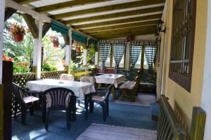 a patio with tables and chairs on a porch at Hondo Holiday Home in Rakovica