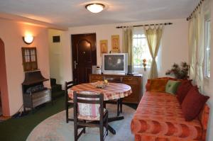 a living room with a table and a couch and a television at Hondo Holiday Home in Rakovica