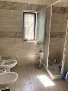 a bathroom with a sink and a toilet and a window at appartamento due camere da letto al centro di Bari in Bari