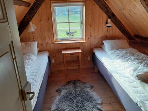 Habitación pequeña con 2 camas en un ático en Brösarp Källagården Vedboden, en Brösarp