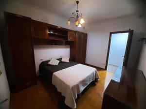 a bedroom with a bed and a chandelier at Fogar dos Petellos, Mondariz. in Mondariz