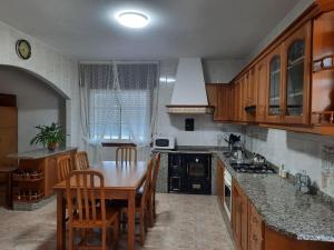 a kitchen with a table and chairs and a kitchen with a stove at Fogar dos Petellos, Mondariz. in Mondariz