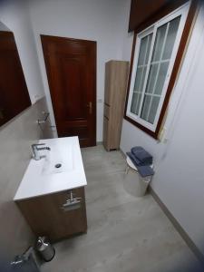 a bathroom with a sink and a toilet and a window at Fogar dos Petellos, Mondariz. in Mondariz +23 photos