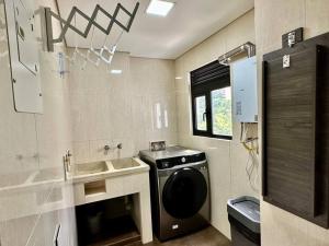 uma casa de banho com uma máquina de lavar roupa e um lavatório em 302 Spacious apartment nice view in El Poblado em Medellín