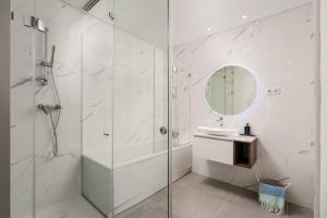 a white bathroom with a shower and a sink at Gaivota Ocean view & 5min walk beach in Luz +12 photos