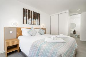 a bedroom with a bed with two towels on it at Gaivota Ocean view & 5min walk beach in Luz