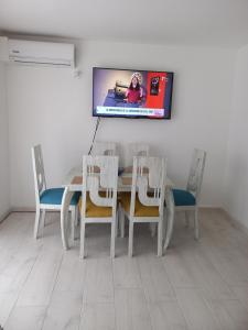a dining room table with chairs and a tv on the wall at Reserva del Peñón Girardot - Apartamento Vacacional Familiar Confort La Esmeralda in Girardot