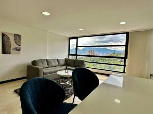 uma sala de estar com um sofá, uma mesa e cadeiras em 302 Spacious apartment nice view in El Poblado em Medellín