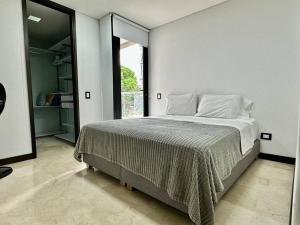 une chambre avec un grand lit et une grande fenêtre dans l'établissement 302 Spacious apartment nice view in El Poblado, à Medellín 51 autres photos