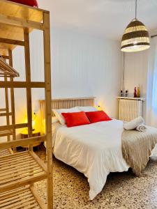 a bedroom with a bed with red pillows and a ladder at Ca La Pia in Corbíns