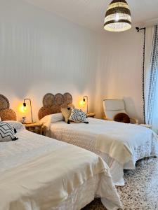 a bedroom with two beds and a chandelier at Ca La Pia in Corbíns