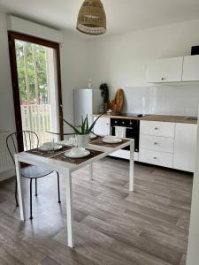 a white kitchen with a table and chairs in it at Allée des cedres in Villepinte