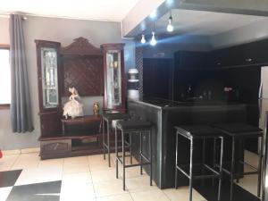 un bar con taburetes negros en una habitación en Villa Caroline, en Antsirabe