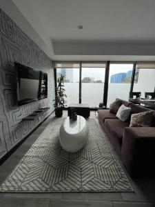 un soggiorno con divano e TV di Senua - Moderno y artistico apartamento a Guatemala