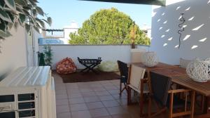 a patio with a table and chairs and a fence at Garden Villa, Cosy House by the sea in Praia Verde