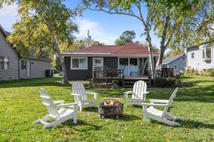 een groep witte stoelen en een vuurplaats in een tuin bij Hickory Hideaway- Dock on Lake Winnebago in Oshkosh