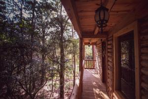 a porch of a log cabin with a light on it at Cabañas Los Encinos in Acaxochitlán