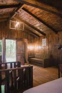 ein Wohnzimmer mit einem Sofa in einem Zimmer mit Holzwänden in der Unterkunft Cabañas Los Encinos in Acaxochitlán