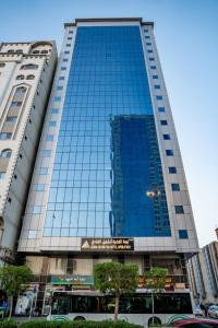 un grand bâtiment avec des fenêtres bleues dans une ville dans l'établissement فندق ليمة الفضية - Leema Al Fadya Hotel, à La Mecque
