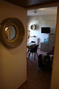 sala de estar con mesa y espejo en la pared en Appartamento Arnolucci, en Rovere