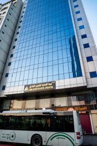un bus garé devant un grand bâtiment dans l'établissement فندق ليمة الفضية - Leema Al Fadya Hotel, à La Mecque