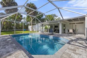 una piscina con pérgola y una casa en Tropical Haven in Ft. Myers, en Fort Myers