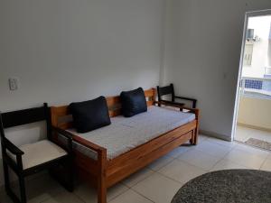 1 cama con 2 almohadas y 1 silla en una habitación en Quarto e Sala - 200 M. Praia dos Milionários en Ilhéus