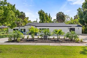 une maison blanche avec des palmiers devant elle dans l'établissement Tropical Haven in Ft. Myers, à Fort Myers