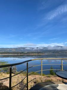 uma vista para um lago a partir de uma varanda em Guatavita Glamping club em Bogotá