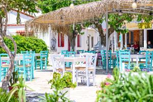 a group of tables and chairs with blue chairs at Old Villa Ormos in Ríva