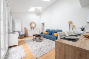 a living room with a blue couch and a table at Appartement Fransokyo - Welkeys in Serris