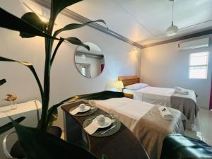 ein Hotelzimmer mit 2 Betten und einer Pflanze in der Unterkunft POUSADA BELLA CANASTRA in Piuí