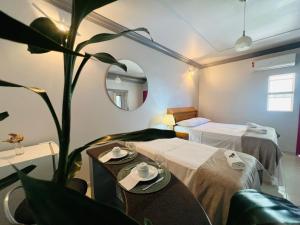 a hotel room with two beds and a plant at POUSADA BELLA CANASTRA in Piumhi
