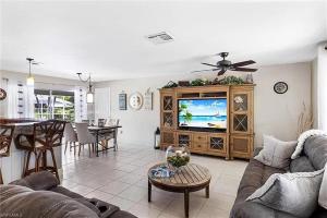 Una sala de estar con un sofá y un televisor. en Tropical Breeze Canal Waterfront Home, Heated Pool, en Cabo Coral