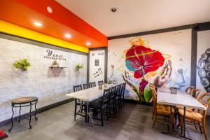 un restaurant avec des tables et des chaises et une grande fresque murale. dans l'établissement Hotel Rose Ensenada, à Ensenada